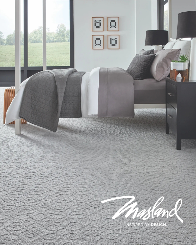 A modern bedroom featuring newly installed grey patterned carpet by Prosource of Savannah in Savannah, GA.