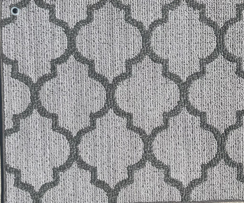 A close-up view of a grey patterned carpet sample offered by Erin Wruck Consulting LLC in Converse, TX
