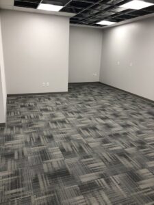 An office space featuring newly installed grey patterned carpet tiles by Grand Rapids Flooring in Grand Rapids, MI.