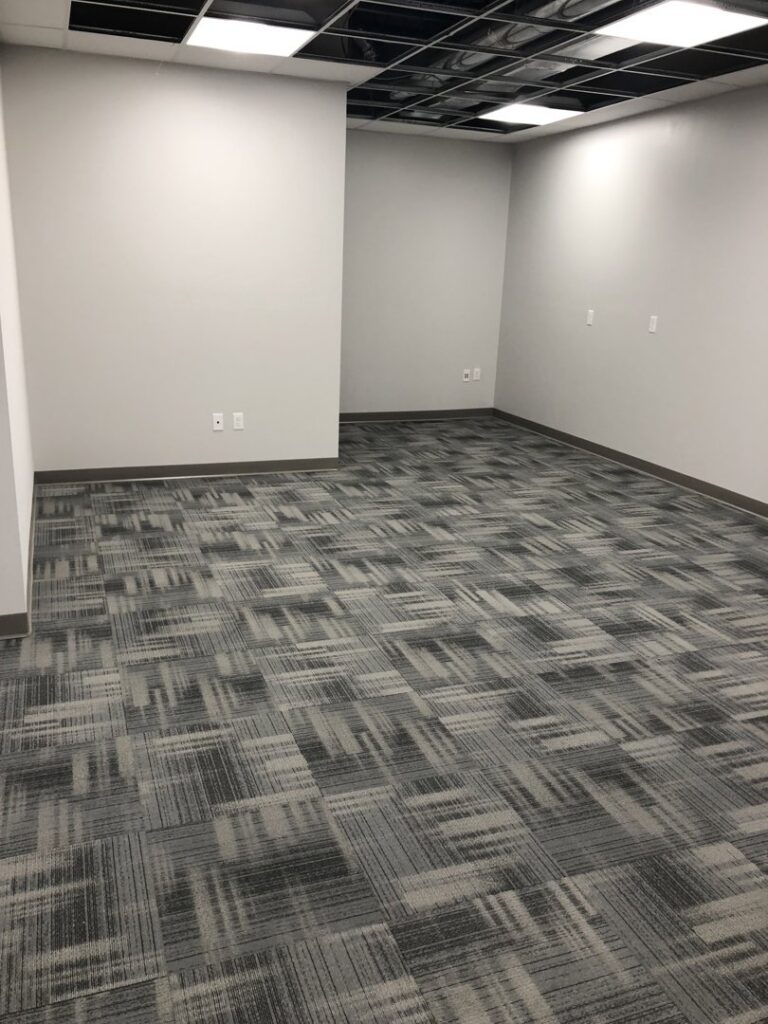 An office space featuring newly installed grey patterned carpet tiles by Grand Rapids Flooring in Grand Rapids, MI.