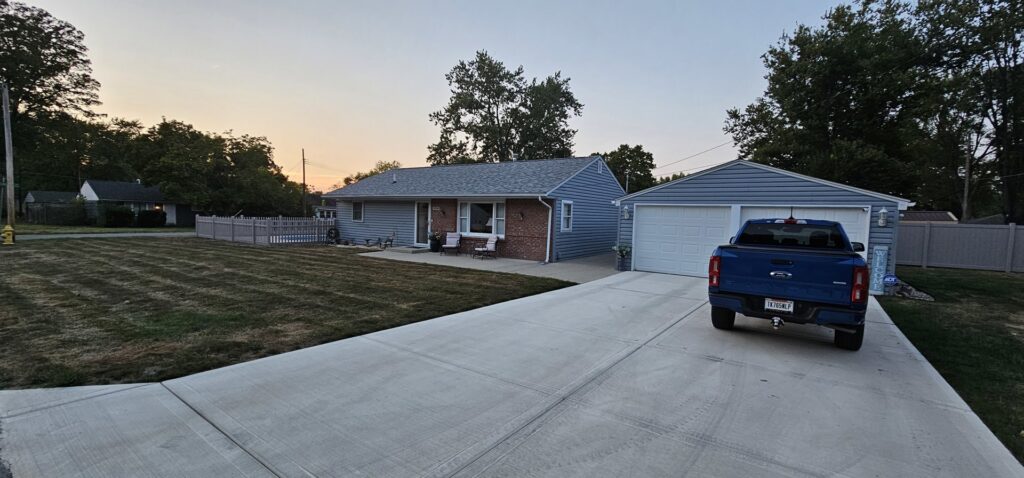 A light grey picket fence installed around a residential house and pool area by Render Fences in Fishers, IN.