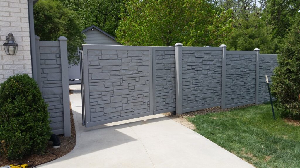 A grey stone-look privacy fence with a double gate installed by Sharper Image Fence in Fort Wayne, IN.