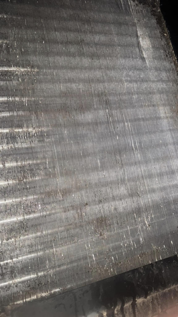 A grimy HVAC condenser coil requiring professional cleaning to restore efficiency by Charlie Foxtrot HVAC in Gilbert, AZ.