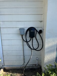 A Grizzl-E electric vehicle charger installed on an exterior wall by Positive Electricians in Van Nuys, CA.