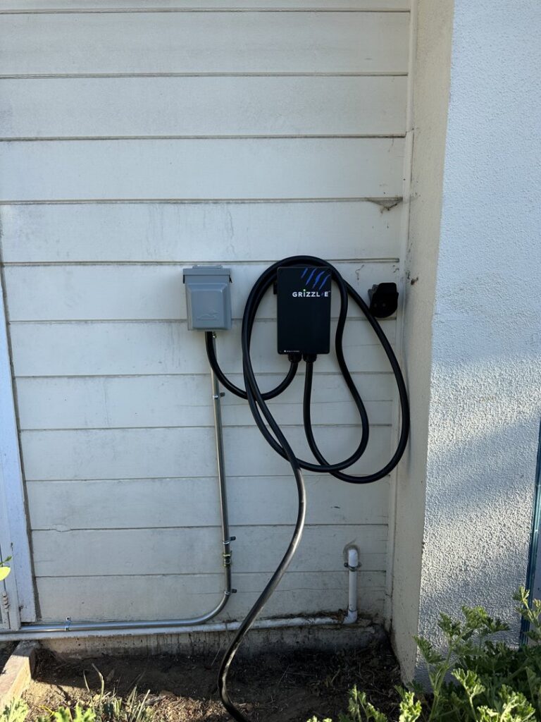 A Grizzl-E electric vehicle charger installed on an exterior wall by Positive Electricians in Van Nuys, CA.