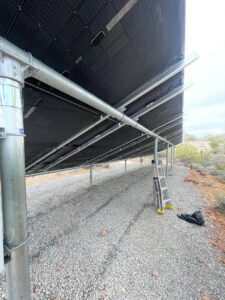 The support structure and wiring underneath ground-mounted solar panels by HomeRun Electric LLC in Arlington, TX