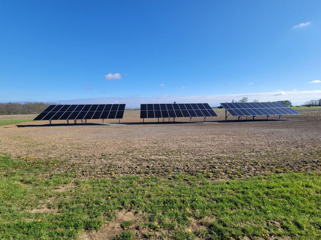 Ground-mounted solar panels installed in a field by All Circuit Electrical LLC, providing renewable energy in Bryant, IN.