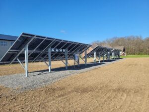 The underside structure and wiring of ground-mounted solar panels installed by All Circuit Electrical LLC in Bryant, IN.