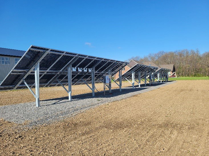 The underside structure and wiring of ground-mounted solar panels installed by All Circuit Electrical LLC in Bryant, IN.