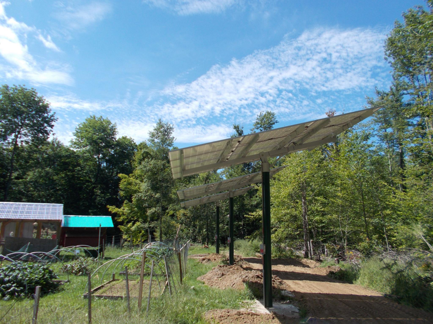Ground-mounted solar panels installed by Metruk's Electrical Contracting, Inc. under a blue sky in Underhill, VT.