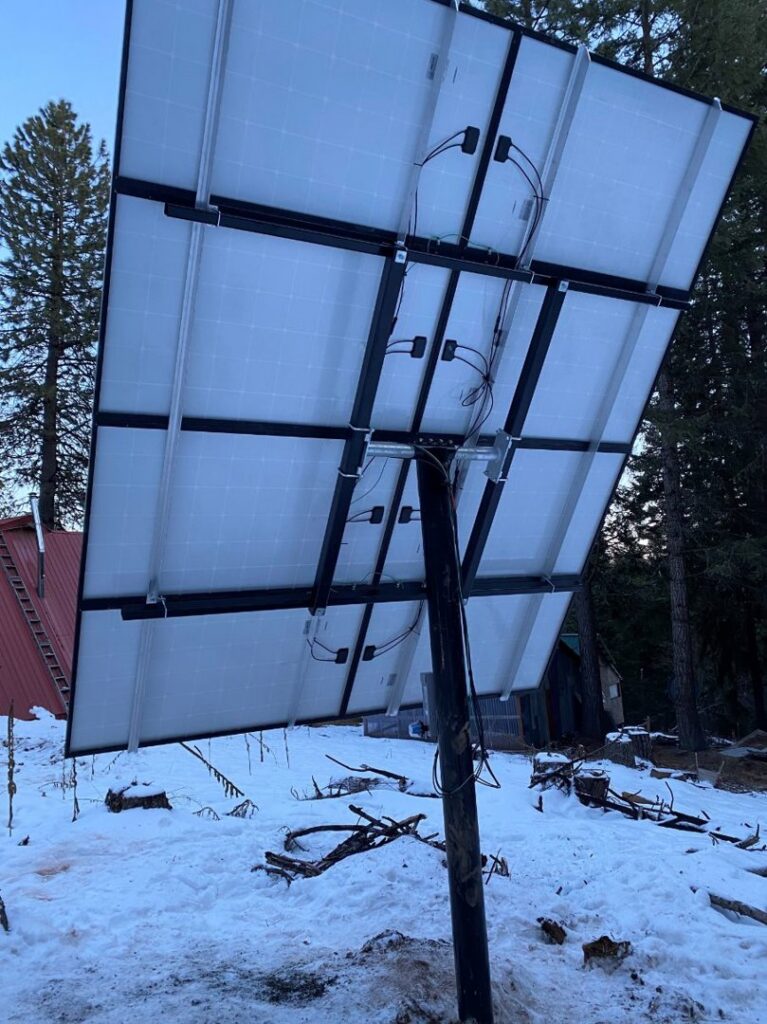 Underside of ground-mounted solar panels installed in a snowy landscape by J C Electric & Solar in Lewiston, ID
