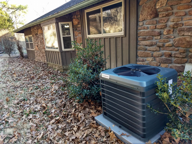 An outdoor Guardian air conditioning unit installed next to a residential home by Pettry Plumbing Heating & Air Inc in Bentonville, AR