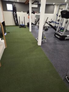 Green turf carpet installation in a gym by Espinoza Flooring Inc in Woburn, MA.
