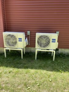 Two Haier outdoor mini-split condenser units installed on stands by Excel Mechanical and Construction LLC in Brunswick, ME