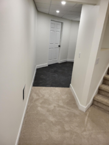 A hallway and stairs featuring new beige carpet installed by Christie Carpets & Blinds in Rochester, NY