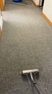 A carpet cleaning wand actively cleaning a hallway carpet, showing the work of B of C Carpet Cleaning LLC in Idaho Falls, ID.