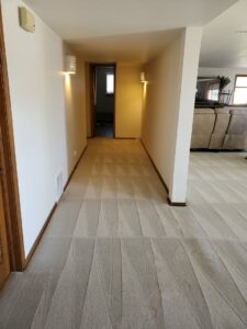 A hallway with light-colored carpet displaying fresh cleaning patterns by Pueblo's Best Carpet & Air Duct Cleaning in Pueblo West, CO.