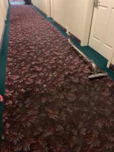 A long hallway with patterned carpet being cleaned with a carpet cleaning wand by Eagle 1 Carpet Cleaning in Reno, NV.