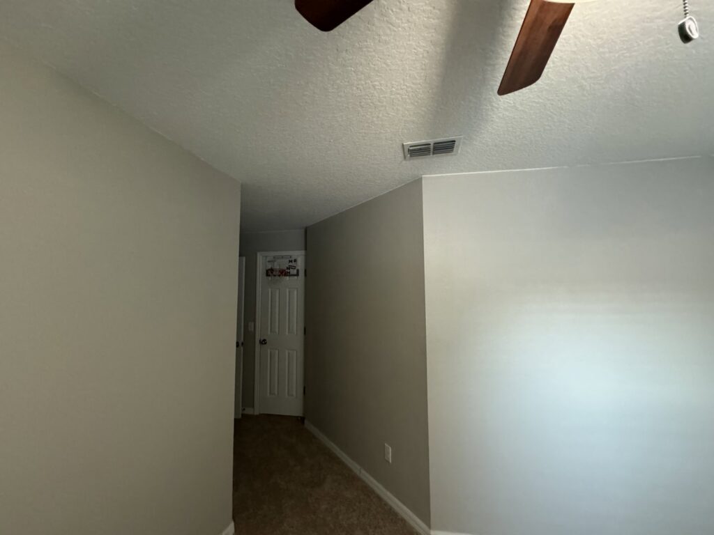 A clean hallway with newly installed light brown carpet flooring by First Quality Carpets Inc. in Orlando, FL