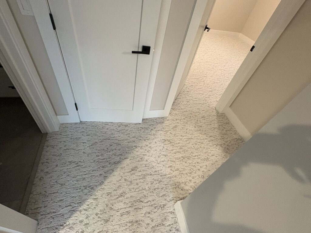 A hallway with new light patterned carpet installed by Flooring World Wide LLC in Plainwell, MI.