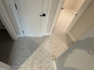 A hallway with new light patterned carpet installed by Flooring World Wide LLC in Plainwell, MI.