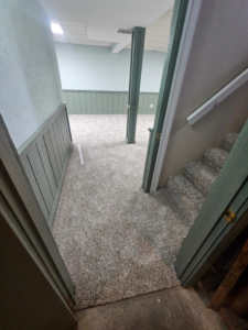 A newly carpeted hallway leading to a room and stairs, installed by Carpets Mostly in Indianapolis, IN