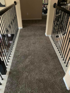 A newly installed brown carpet in a residential hallway, completed by Topline Flooring in Houston, TX.