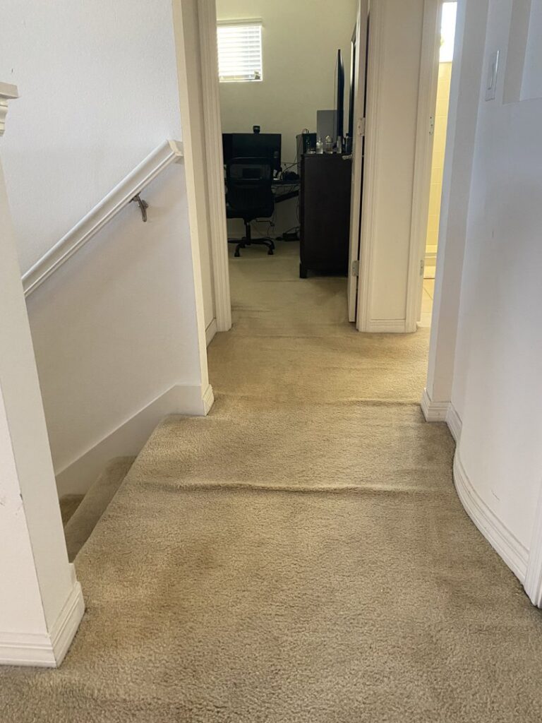 A hallway carpet with visible ripples, indicating a need for stretching or repair by Mr. Carpet Cleaning Orlando, FL.