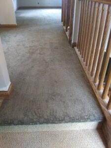A hallway with new carpet and matching carpeted stairs installed by Floors By Roberts in Appleton, WI.