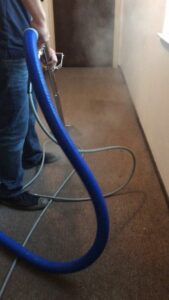 A technician performing steam cleaning on a hallway carpet, showing effective cleaning by Dalia's Carpet Cleaning in San Francisco, CA.