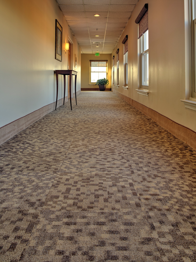 A long hallway featuring a modern patterned carpet tile installation by Direct Solutions Flooring in Baltimore, MD.