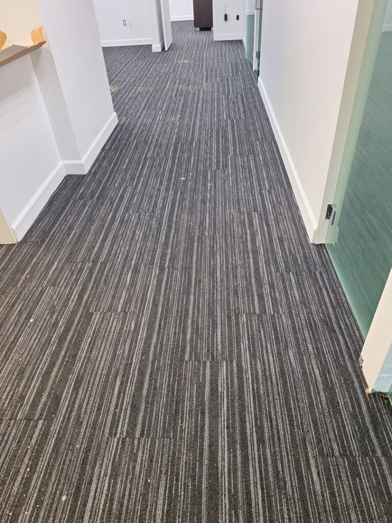 Dark grey striped carpet tiles installed in a hallway by Palmetto Carpet Company in Miami, FL.