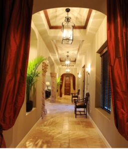 A long hallway showcasing various decorative light fixtures and recessed lighting installed by Castle Electrical & Lighting in Scottsdale, AZ.