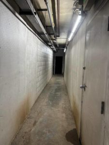 A long hallway with fluorescent lighting and exposed electrical conduit installed on the ceiling by SEI Electric Inc. in Idaho Falls, ID.