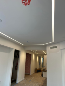 A hallway featuring modern linear LED lighting installed in the ceiling by Krajcer Electric in New Orleans, LA