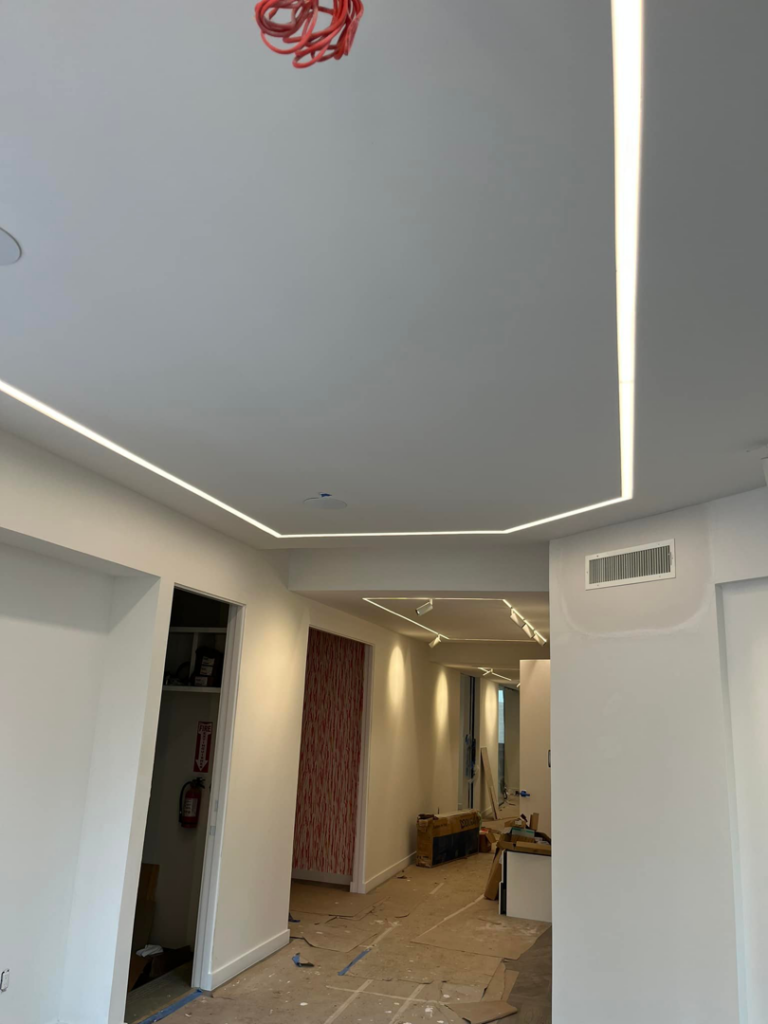 A hallway featuring modern linear LED lighting installed in the ceiling by Krajcer Electric in New Orleans, LA