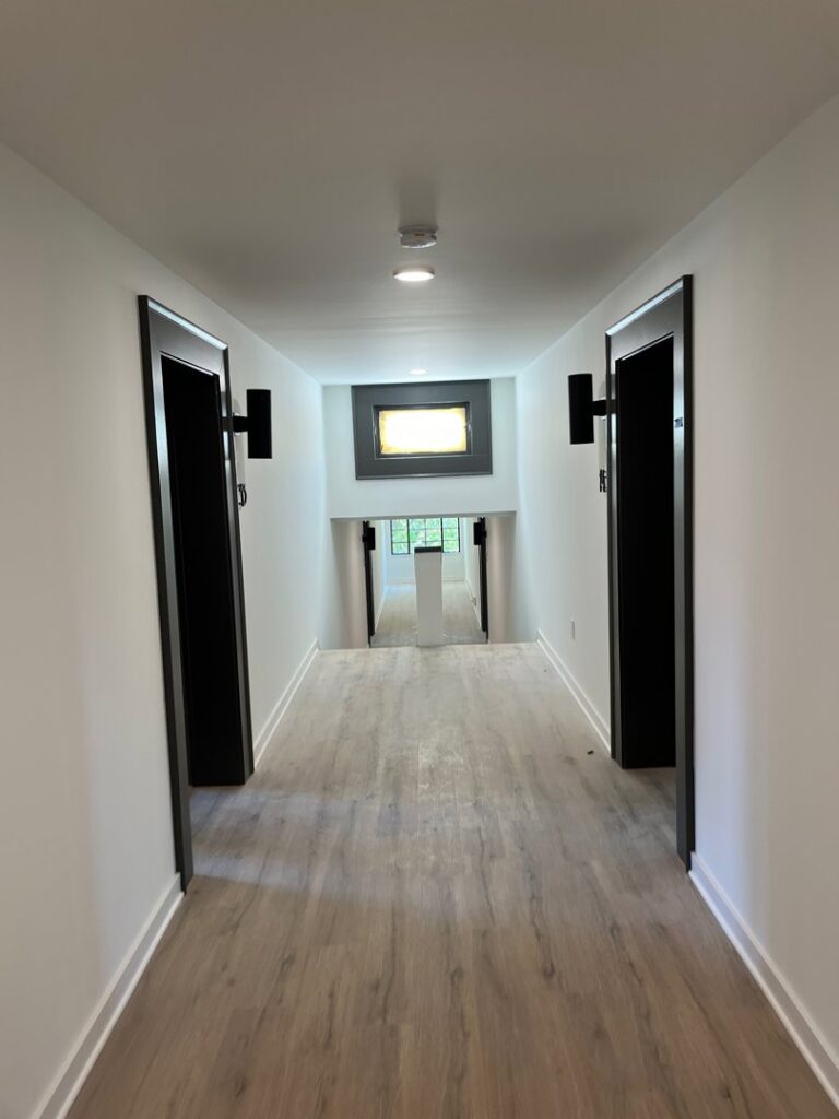 Hallway with modern recessed lighting and wall sconces installed by E-Systems Electrical Inc. in Cumming, GA.