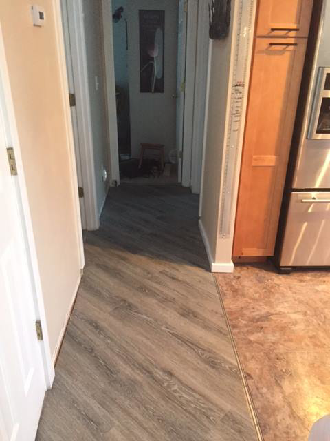 Hallway with newly installed vinyl plank flooring transitioning to another room by Alaska Flor-Wall, Inc. in Anchorage, AK.