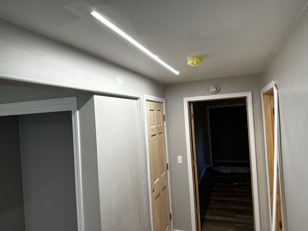 A hallway featuring linear LED lighting and a smoke detector installed by Intel-electric in Anchorage, AK
