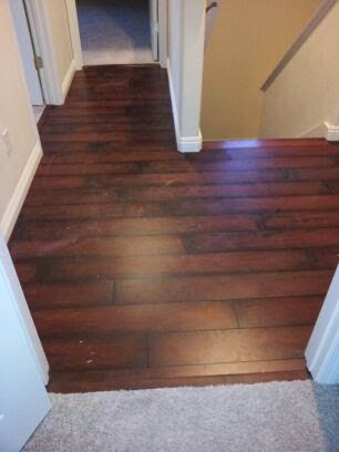 A hallway featuring a transition from dark wood flooring to carpet, installed by Delgado Carpet Services in San Jose, CA