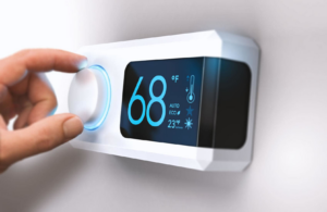 A hand adjusting a modern digital thermostat for heating and cooling at Carpenter Heat Air Electrical in Henderson, TN.