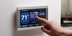 A hand adjusting a smart thermostat, representing modern HVAC control systems by Universal Mechanical Contractor's,Inc. in Lynn, MA