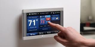 A hand adjusting a smart thermostat, representing modern HVAC control systems by Universal Mechanical Contractor's,Inc. in Lynn, MA