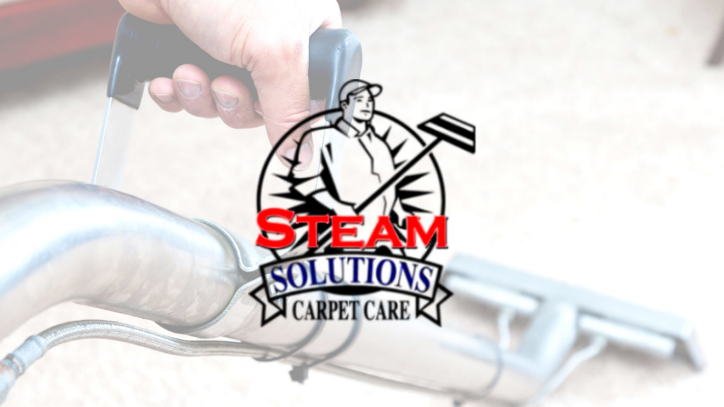 A hand operating a carpet cleaning wand on a carpet, showcasing services by Steam Solutions Carpet Cleaning in San Antonio, TX.
