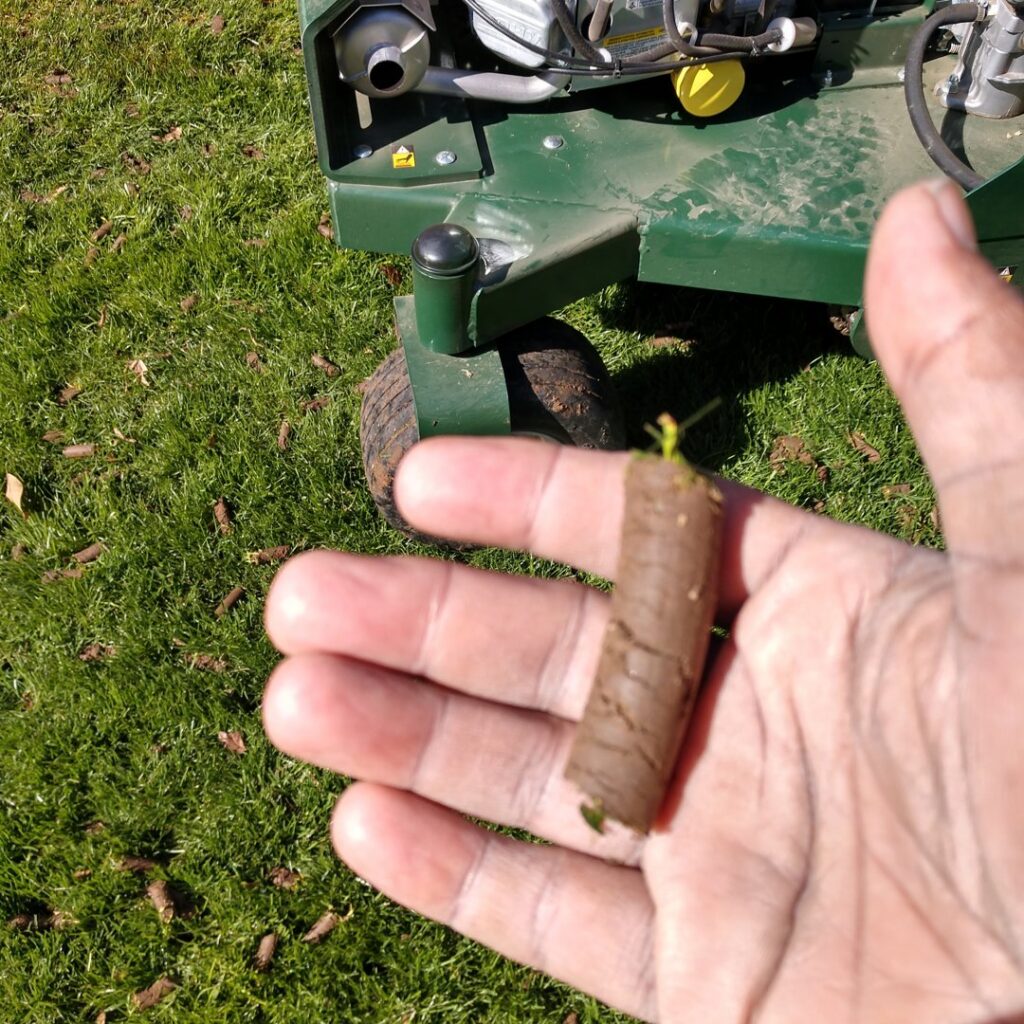 A hand holding a soil core, demonstrating the effectiveness of lawn aeration by Mr. B's Lawn Aeration in Lafayette, IN.