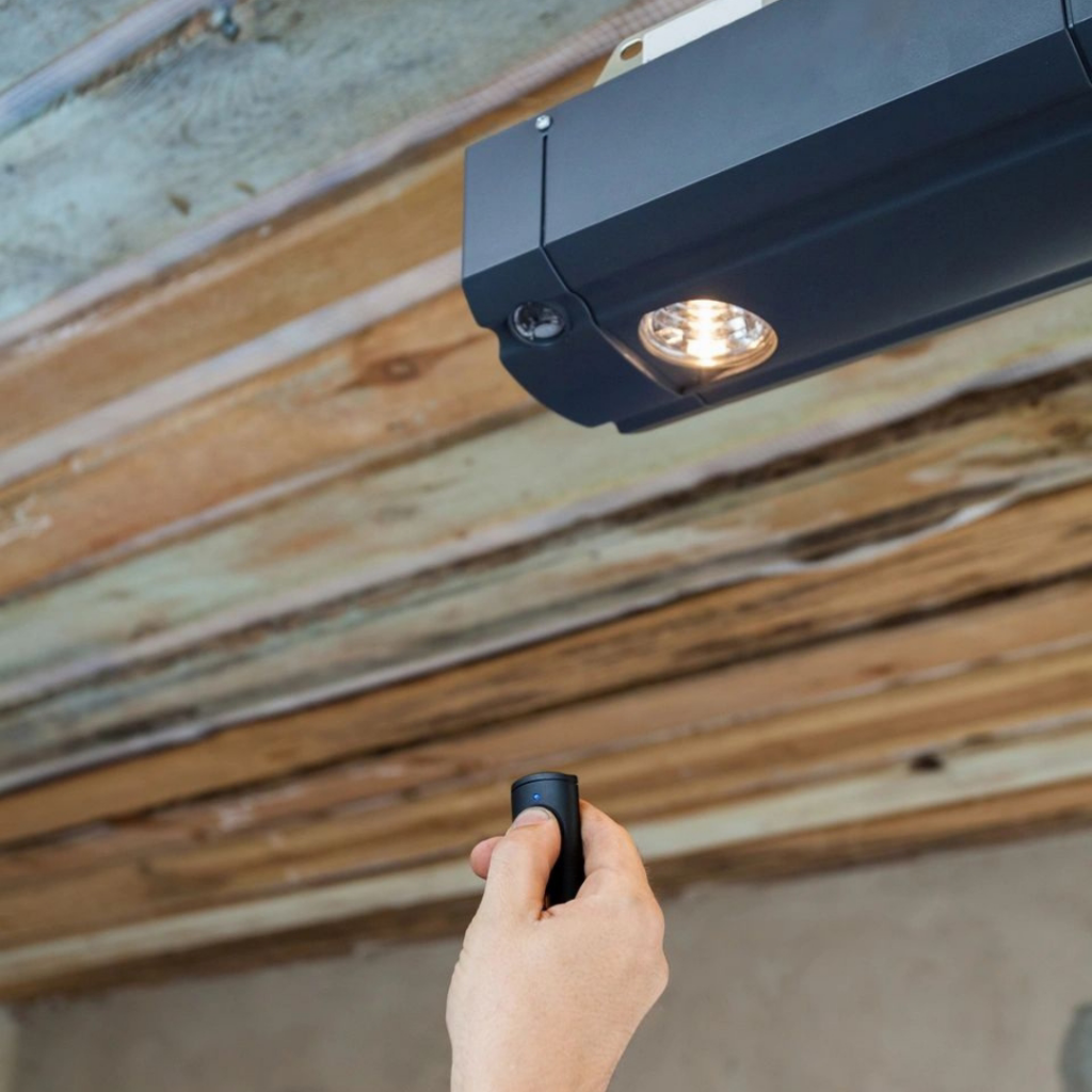 A hand using a remote control to operate a garage door opener installed by Annapolis Garage Doors Inc. in Annapolis, MD.