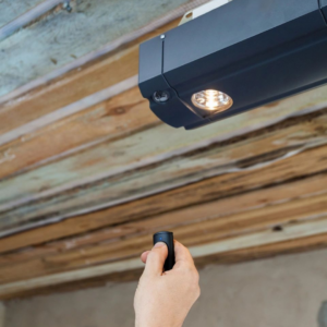 A hand using a remote control to operate a garage door opener installed by Annapolis Garage Doors Inc. in Annapolis, MD.