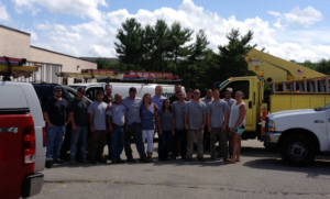 Hannon Electric Inc. crew posing with their work trucks, including a bucket lift, ready for electrical jobs in South Easton, MA.
