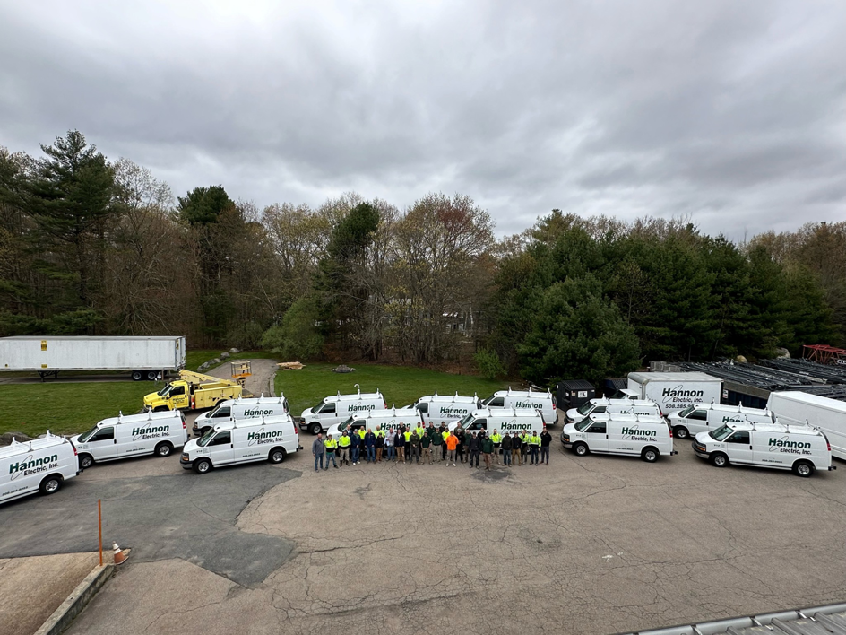 The dedicated team of electricians from Hannon Electric Inc. standing with their fleet of service vans in South Easton, MA.