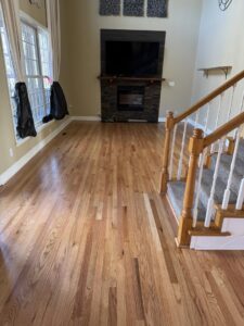 Hardwood floor installation in a living room with carpeted stairs by Augusta Carpet Mart in Augusta, GA.